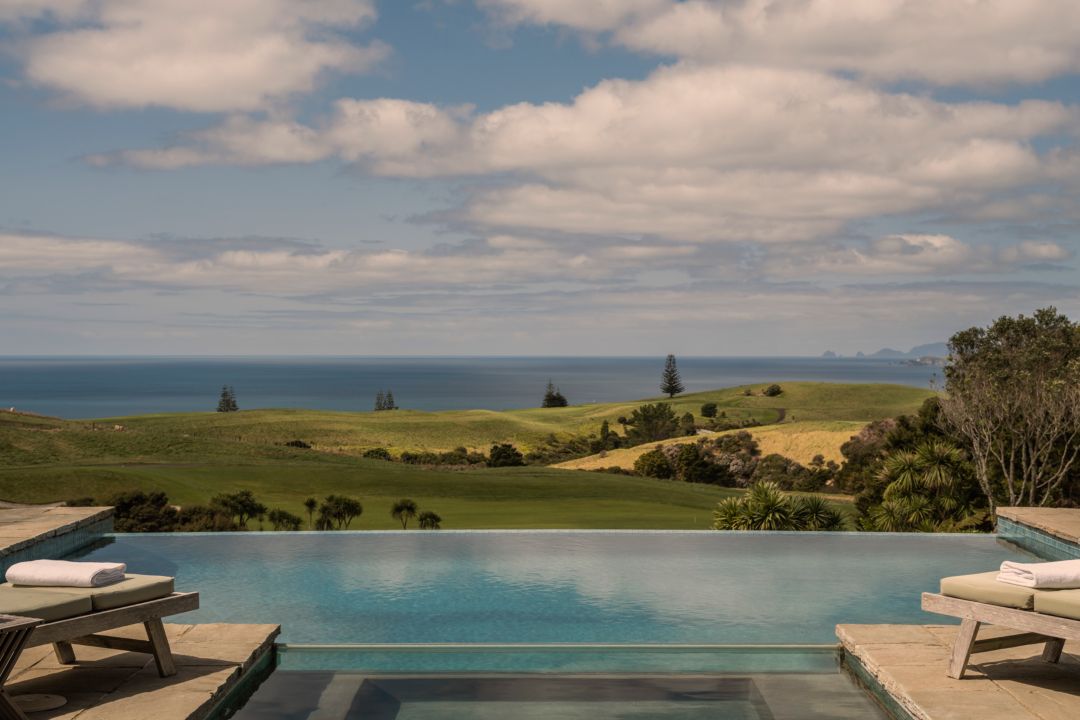 Infinity pool and jacuzzi at a luxury two bedroom villa with pool loungers, overlooking the Kauri Cliffs golf course and out to the Pacific Ocean. 
